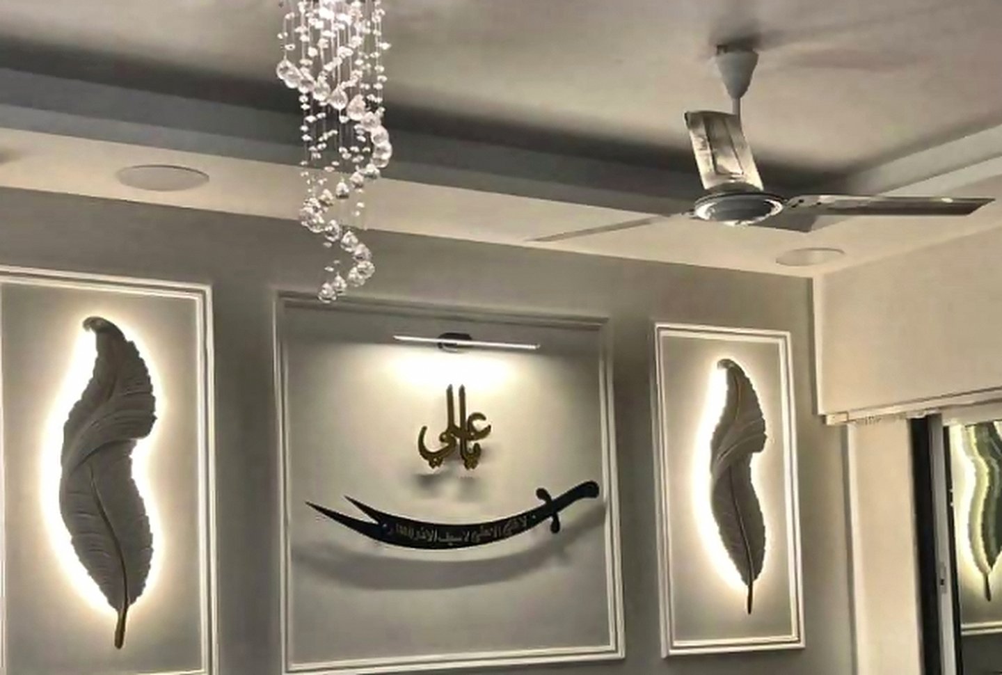 Backlit wall-art panels and false-ceiling detail in a living room