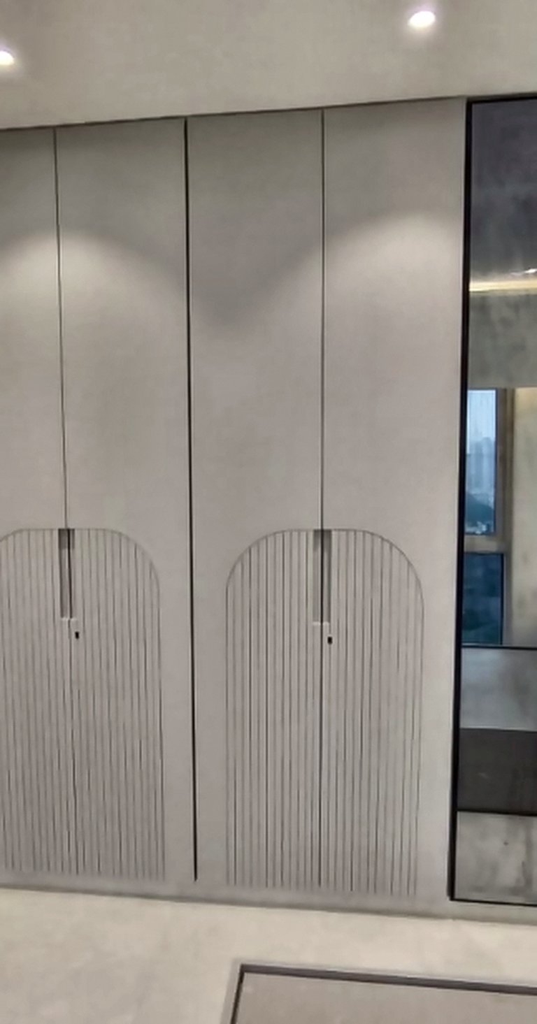 Fluted floor-to-ceiling wardrobe beside a glass partition