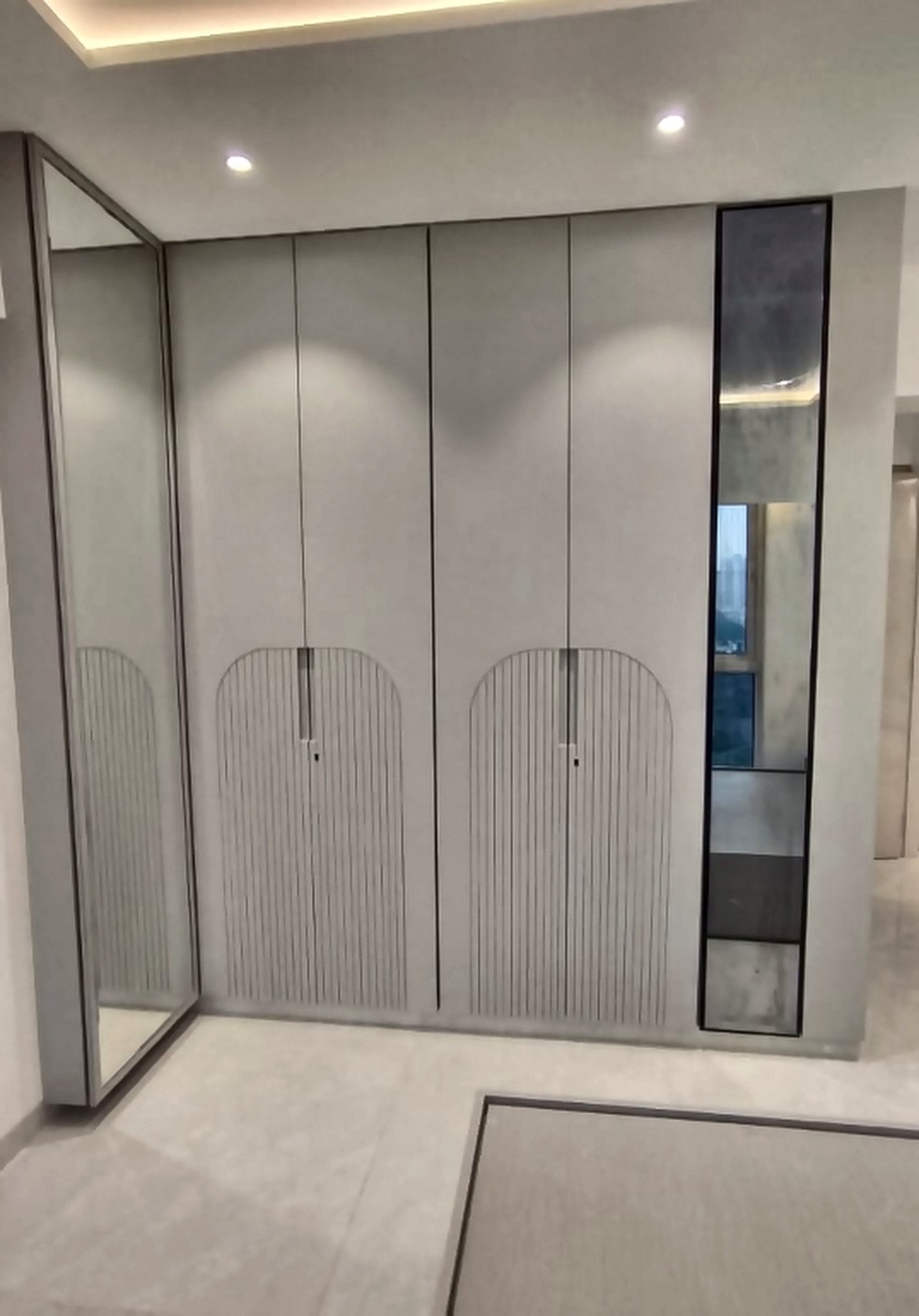 Fluted floor-to-ceiling wardrobe with a mirror panel in a Bangur Nagar bedroom