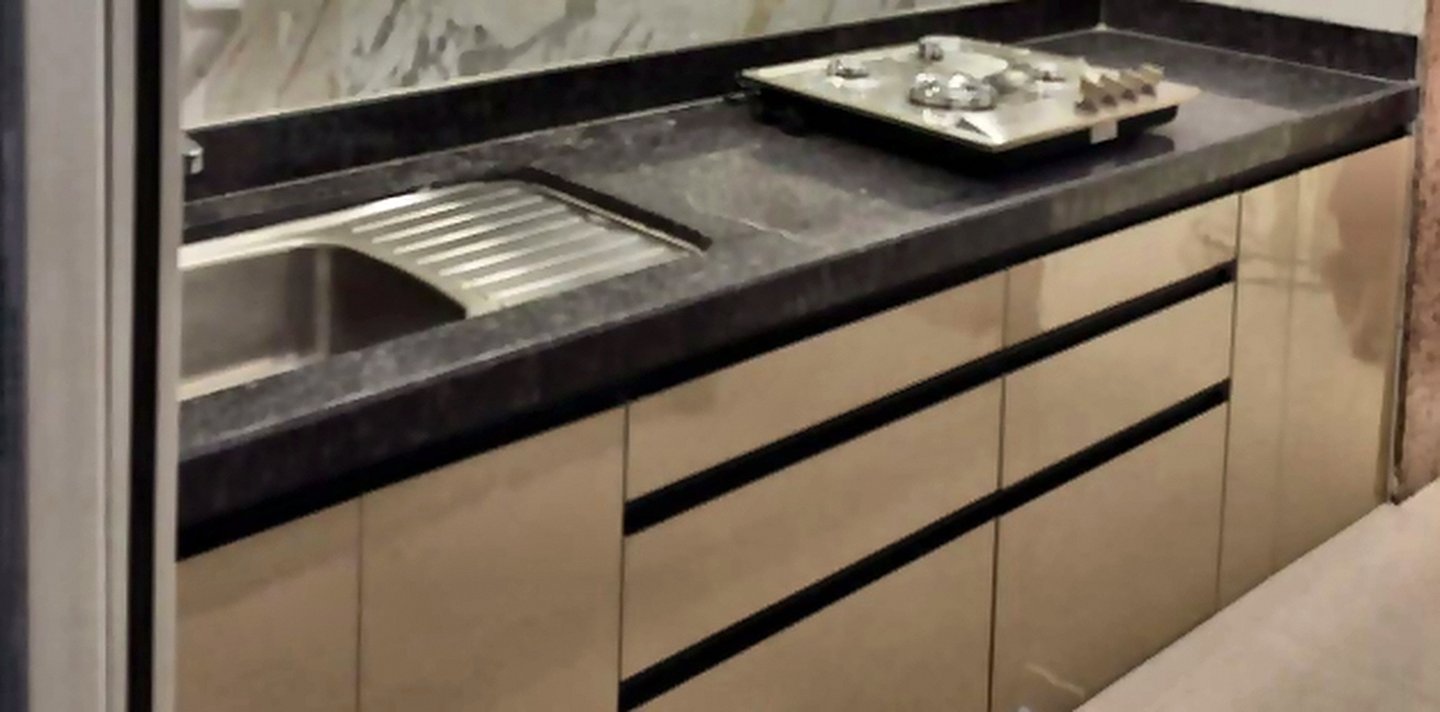 Handleless base cabinets and drawers in a glossy modular kitchen
