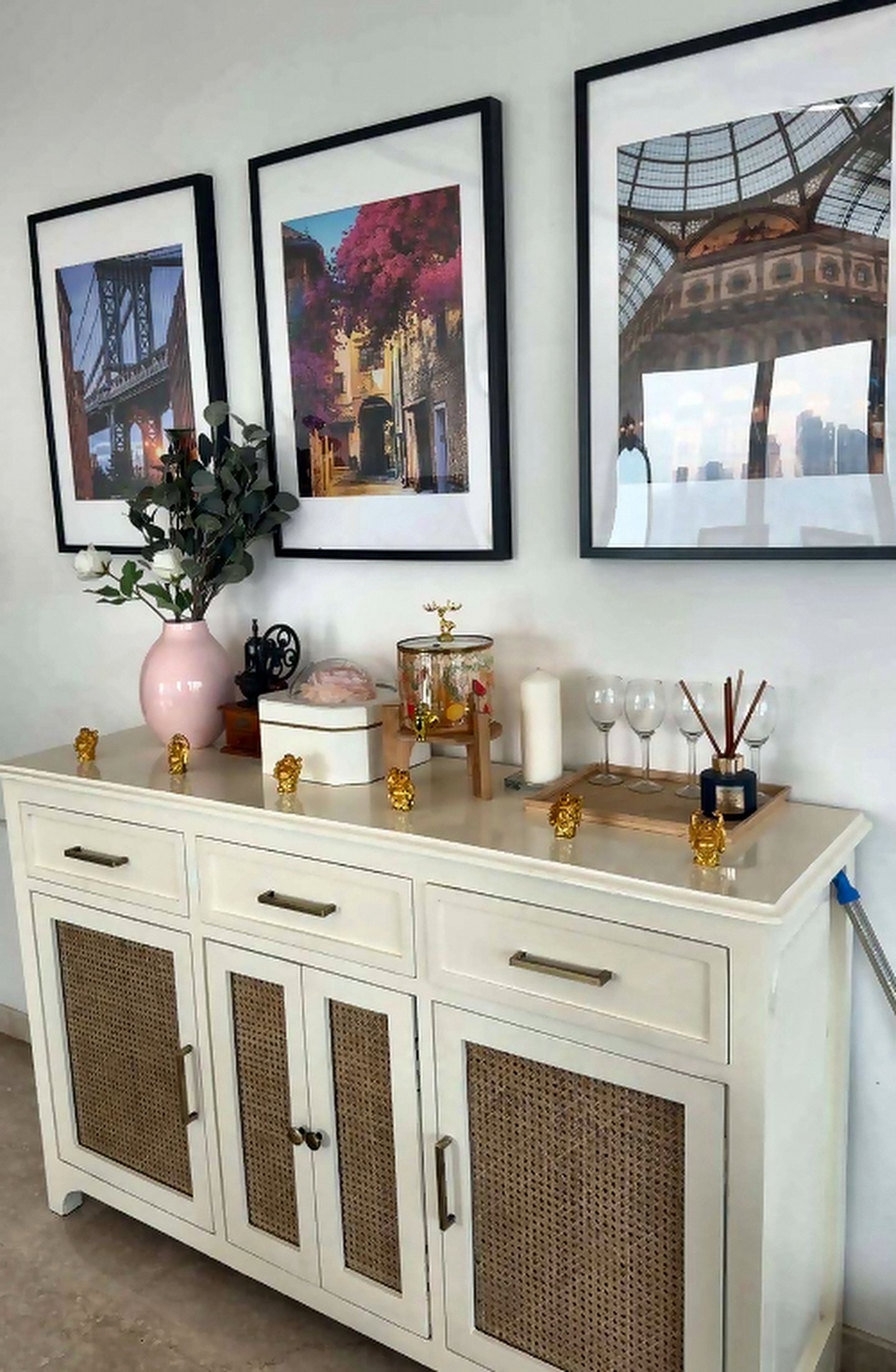 Styled console with a rattan sideboard, framed art and décor accessories in a Mumbai home