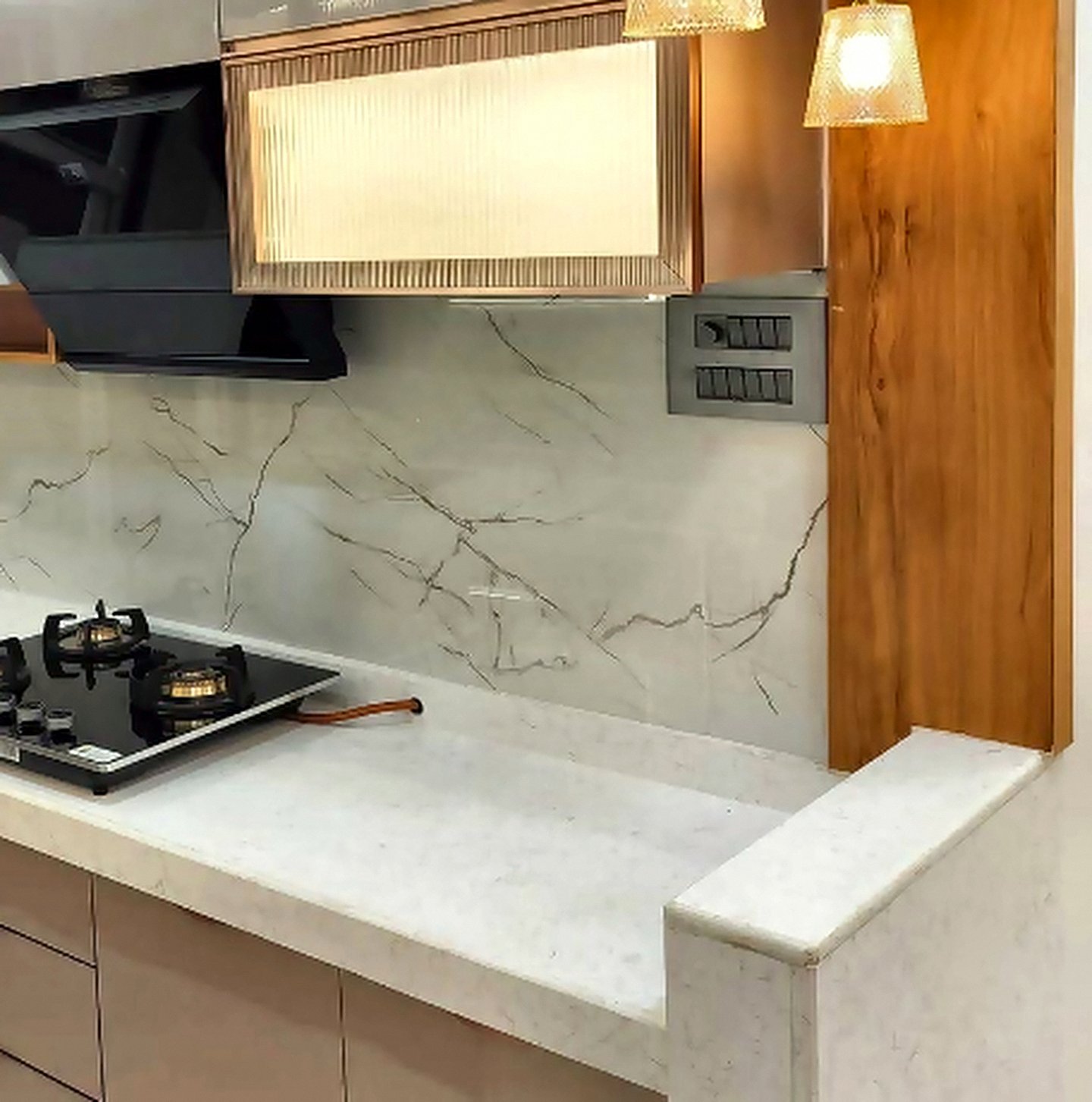 Hob, chimney and marble counter in a beige modular kitchen
