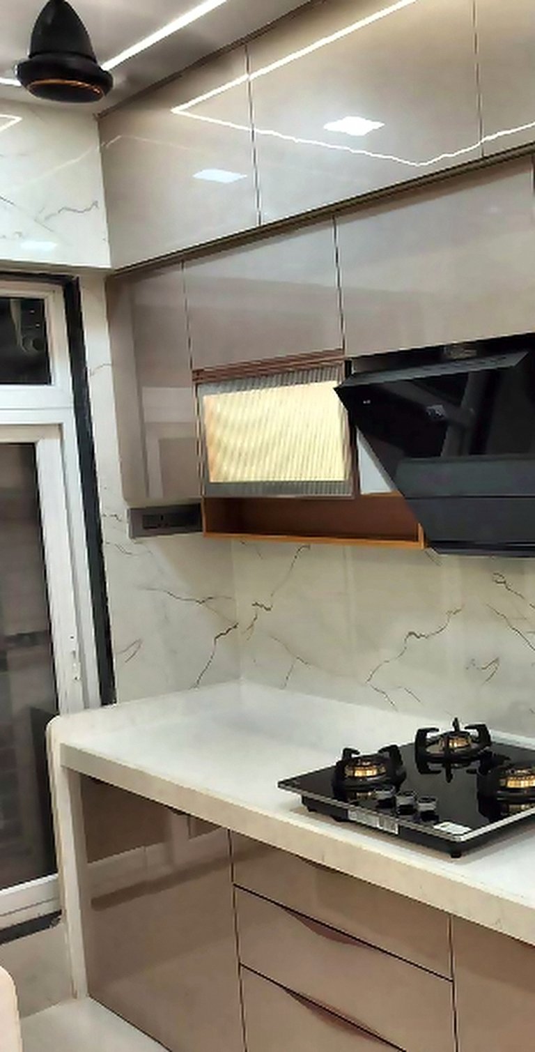 Mirror cladding and pendant lighting detail in a modular kitchen